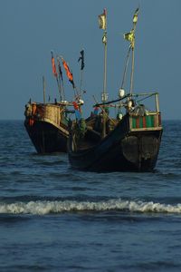 Fishing boat in sea against clear sky