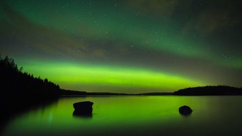 Scenic view of lake against sky at night