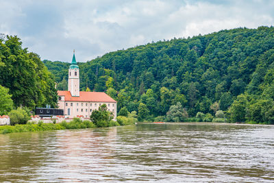 Scenic view of river by buildings against sky