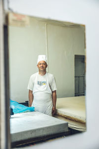 Portrait of a baker looking into a mirror at a bakery in belgrade,