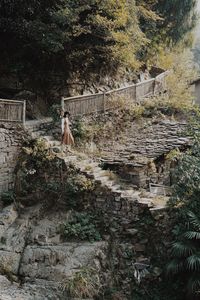 Woman walking on staircase in forest