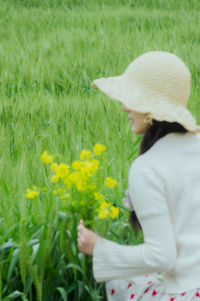 Rear view of woman standing on grassy field