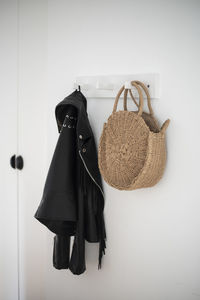 Clothes hanging in basket against wall at home