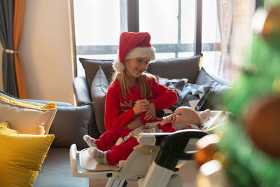 Young woman using laptop while sitting on sofa at home