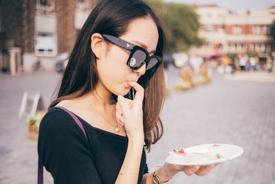 Close-up of woman holding ice cream in city