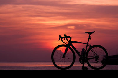 Silhouette bicycle against sky during sunset