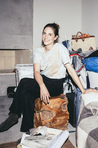 Portrait of smiling woman sitting on wooden seat during relocation of house