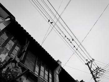 Low angle view of electricity pylon against clear sky