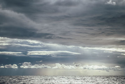 Sunlight streaming through clouds over sea
