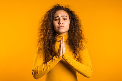 Portrait of woman with yellow hair against orange background