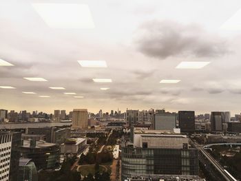 Cityscape against cloudy sky