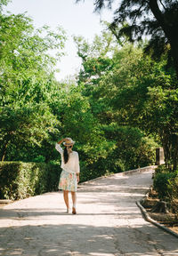 Rear view of woman walking on walkway in park