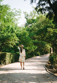 Full length of woman standing on tree trunk