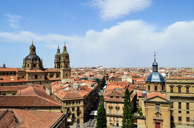 Buildings in city against cloudy sky