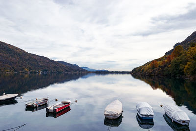 Boats moored in lake against sky