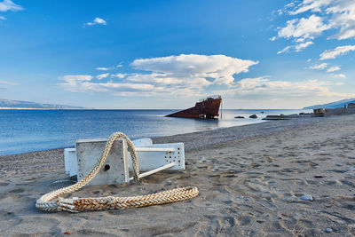 Deck chairs on beach against sky