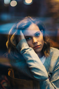 Close-up portrait of beautiful young woman with hand in hair