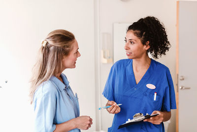 Female nurse discussing with doctor about medical report in hospital