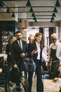 Smiling businesswoman with colleagues in restaurant