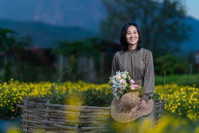 Portrait of smiling woman standing against yellow wall