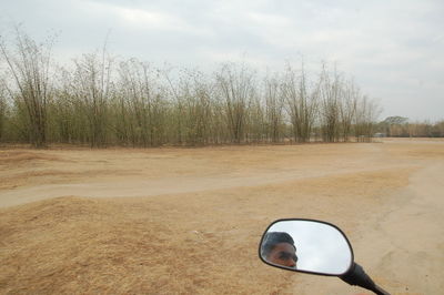 Dirt road on field against sky