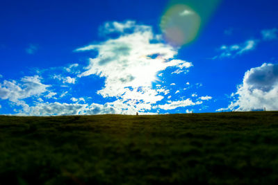 Scenic view of grassy field against cloudy sky