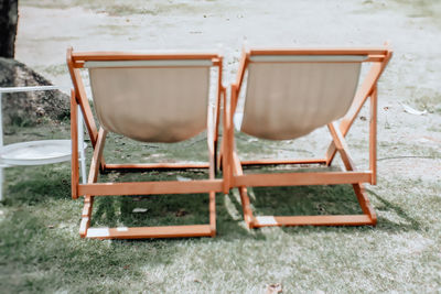 Empty chairs and table on field