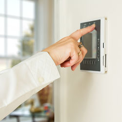 Cropped hand using intercom at home