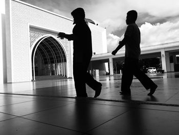 Rear view of silhouette people standing on tiled floor