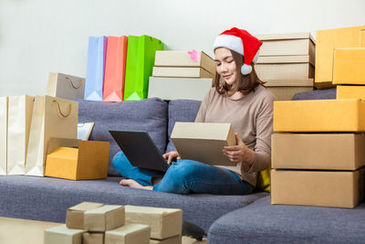 Full length of senior woman sitting on sofa at home