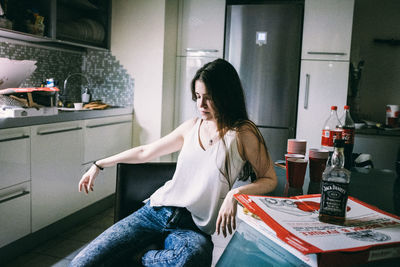 Woman sitting on table at home