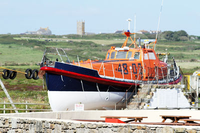 Ship moored on shore against sky