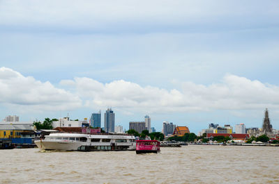 Sea by cityscape against sky