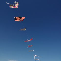 Low angle view of airshow against clear blue sky