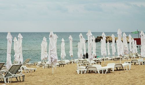 Chairs on beach against sky