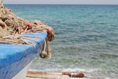 Buoy and fishing net on boat against sea