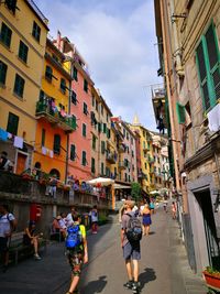 People walking on street amidst buildings in city