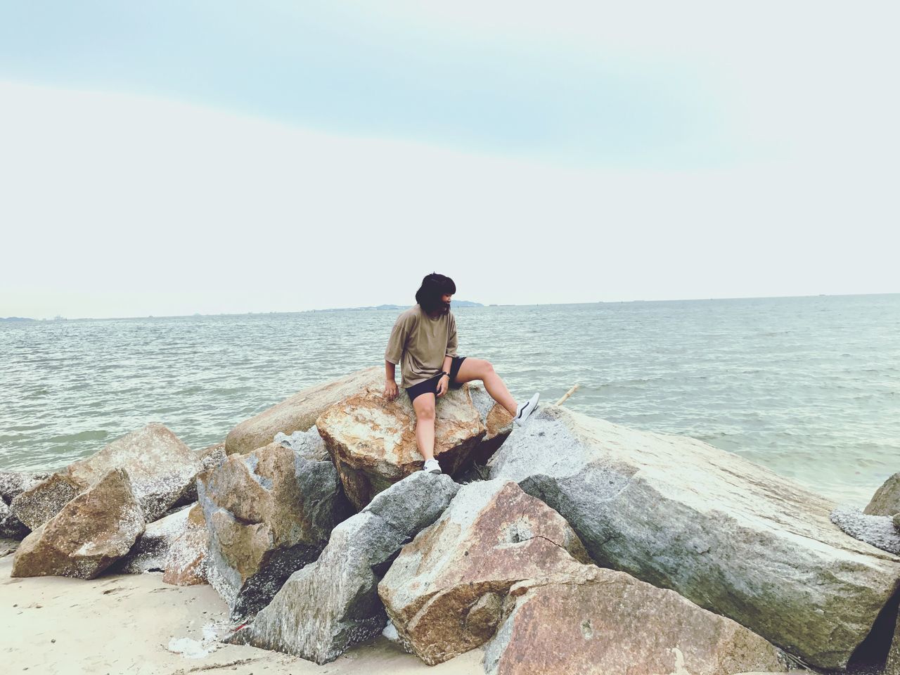 sea, horizon over water, rock - object, water, rear view, nature, real people, one person, scenics, sky, day, beauty in nature, tranquil scene, outdoors, clear sky, leisure activity, full length, tranquility, men, standing, sitting, fishing pole, people