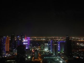 Illuminated cityscape against sky at night