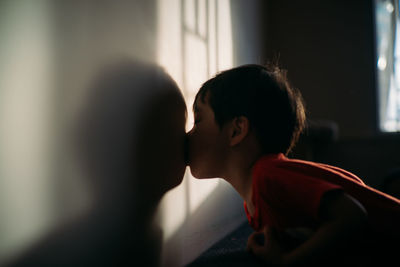 Portrait of boy looking through window