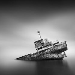 Abandoned ship in sea against sky