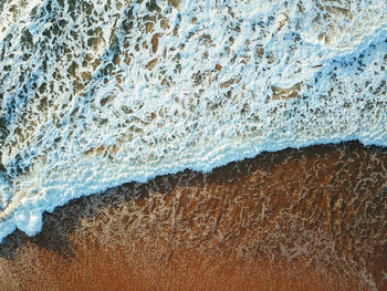 Aerial view of waves rushing at beach