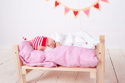 Cute baby sleeping on small bed at home