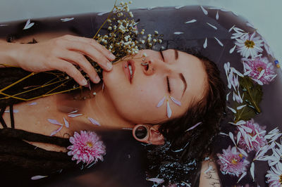 Close-up portrait of woman lying down on plant