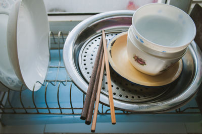 High angle view of bowls with plates and chopsticks in rack