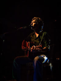 Man playing guitar at night