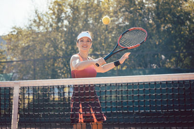 Woman playing with ball in tennis court