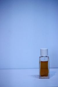 Close-up of glass jar on table against blue background