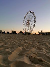Ferris wheel on beach against clear sky