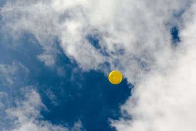 Low angle view of balloon drifting away against sky